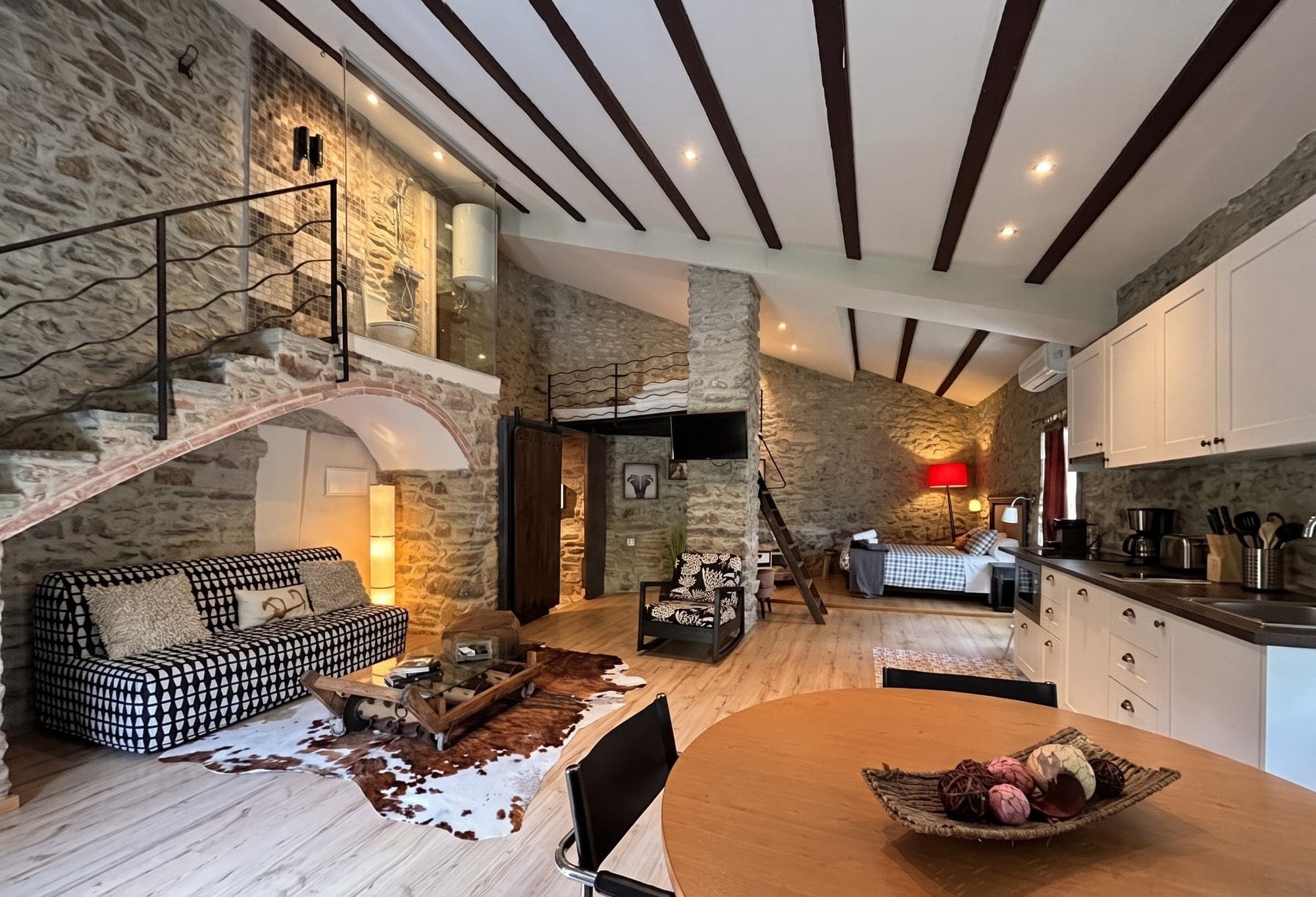 Vista general de l'Apartament, un dúplex de pedra vista amb altell, cuina completa i saló