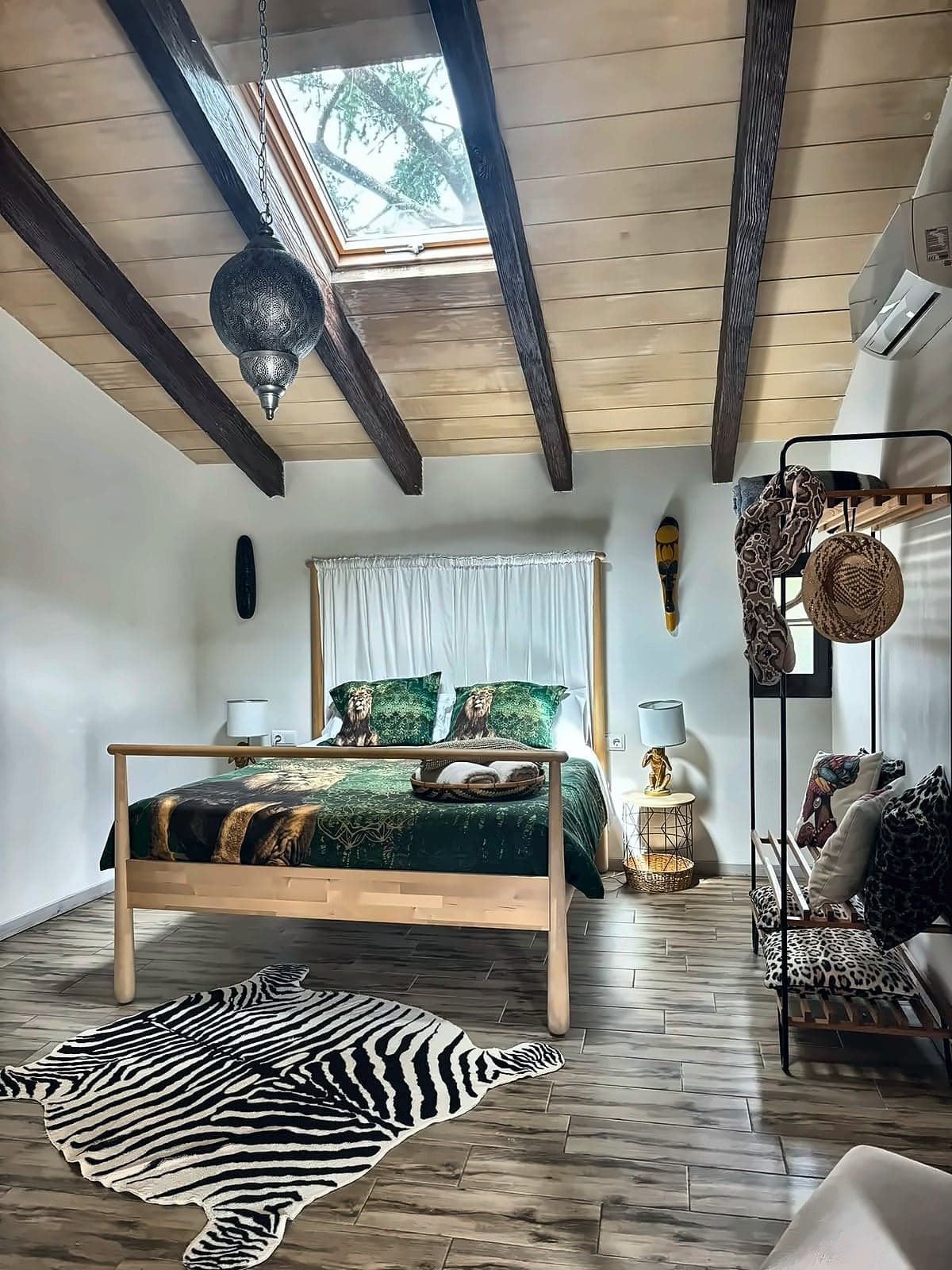 Cama con dosel de cortinas blancas, ropa de cama estampada de leones y claraboya, Habitación Africana
